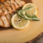 Grilled Chicken Shawarma Mediterranean Diet with delicious grill marks served with lemon and a sprig of rosemary spice