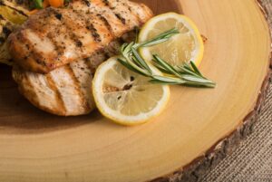 Grilled Chicken Shawarma Mediterranean Diet with delicious grill marks served with lemon and a sprig of rosemary spice