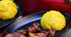Rice Pilaf for the Mediterranean Diet bright yellow scoop of rice contrast the grilled chicken on a black plate